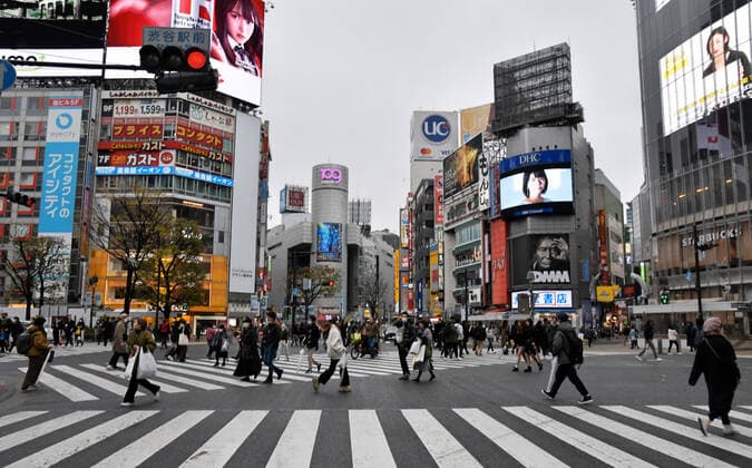 Pedestrians wearing face masks pass through a scramble crossing at Shibuya shopping district in Tokyo, Japan on Sunday, March 29, 2020. Streets in normally busy Tokyo areas such as the Shibuya, Shinjuku and Ginza shopping district are lightly populated.  TKP2020032915 KEIZOxMORI
