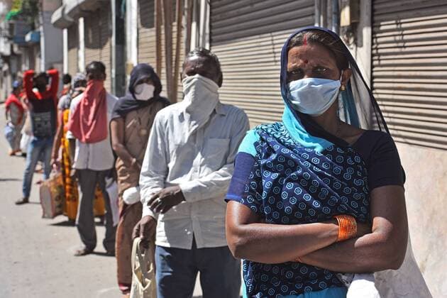 NEW DELHI, INDIA - MARCH 29: People stand in a queue to collect essentials distributed by Government of India on Day 5 of the 21 day nationwide lockdown imposed by PM Narendra Modi to curb the spread of coronavirus, outside a PDS Ration Shop, at Gole Market, on March 29, 2020 in New Delhi, India. (Photo by Sanchit Khanna Hindustan Times ) Government People Provide Food To Homeless And Poor Amid Lockdown To Prevent Covid 19