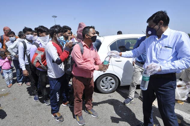 NOIDA, INDIA - MARCH 29: People distribute food among migrant workers walking to their homes, on day 5 of the 21 day nationwide lockdown imposed by PM Narendra Modi to check the spread of coronavirus, at Yamuna Expressway Zero Point, on March 29, 2020 in Noida, India. (Photo by Sunil Ghosh Hindustan Times ) Government People Provide Food To Homeless And Poor Amid Lockdown To Prevent Covid 19