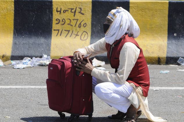 NOIDA, INDIA - MARCH 29: A migrant worker headed back home pauses for break, on day 5 of the nationwide lockdown imposed by PM Narendra Modi to check the spread of coronavirus, at Yamuna expressway zero point, on March 29, 2020 in Noida, India. (Photo by Sunil Ghosh Hindustan Times ) Migrant Workers Head Home In Coronavirus Lockdown