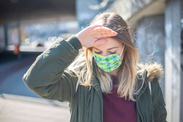 junge Frau mit Mundschutz in der Stadt