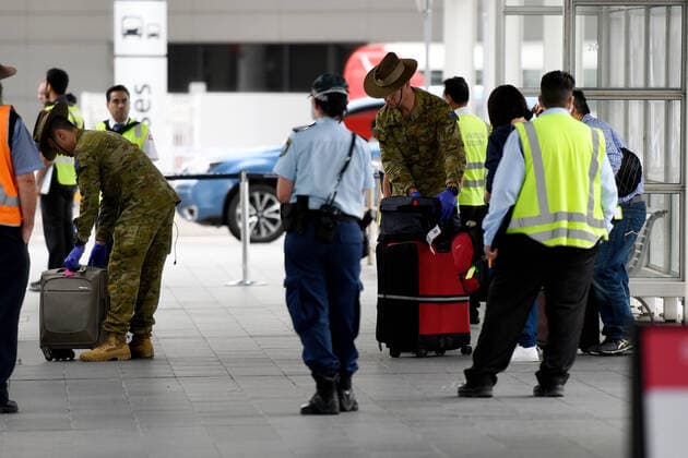AUSTRALIA CORONAVIRUS COVID-19, Australian Defence Force (ADF) personnel escort returning overseas travellers to charter buses at Sydney International Airport in Sydney, Monday, March 30, 2020. Travellers and Australian residents who arrive into the country from overseas are being sent straight to makeshift quarantine facilities across Australia. Travellers will spend 14 days of quarantine in state-funded hotel rooms, with doors guarded by state police, defence personnel or private security guards.( NO ARCHIVING, EDITORIAL USE ONLY, NO USE IN BOOKS WITHOUT CONSENT SYDNEY NSW AUSTRALIA  Copyright: xBIANCAxDExMARCHIx 20200330001460797336