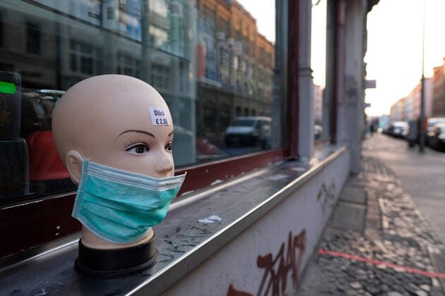 Vor einem Laden in der Oranienstraße in Berlin-Kreuzberg weist ein Puppenkopf mit einem Mundschutz auf den Verkauf von Atemschutzmasken hin. snapshot-photography xK.M.Krause