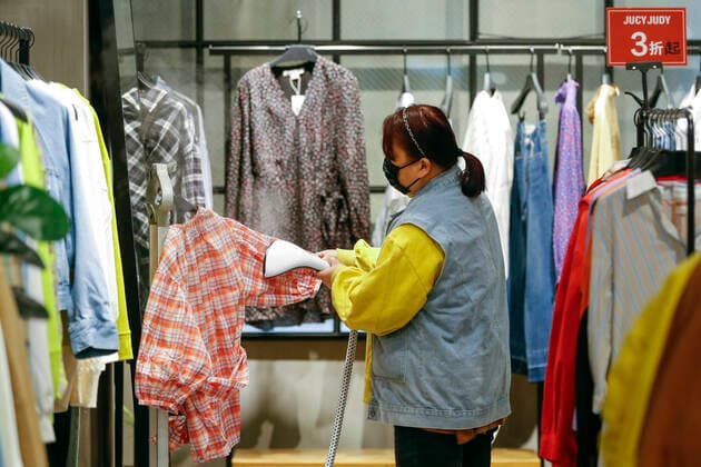 (200330) -- WUHAN, March 30, 2020 -- A sales clerk irons clothes at a shopping mall in Wuhan, central China s Hubei Province, March 30, 2020. Many shopping malls in Wuhan reopened on Monday. ) CHINA-WUHAN-SHOPPING MALL-REOPENING (CN) ShenxBohan 