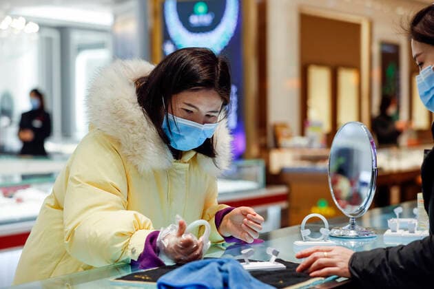 (200330) -- WUHAN, March 30, 2020 -- A customer selects a bracelet at a shopping mall in Wuhan, central China s Hubei Province, March 30, 2020. Many shopping malls in Wuhan reopened on Monday. ) CHINA-WUHAN-SHOPPING MALL-REOPENING (CN) ShenxBohan 
