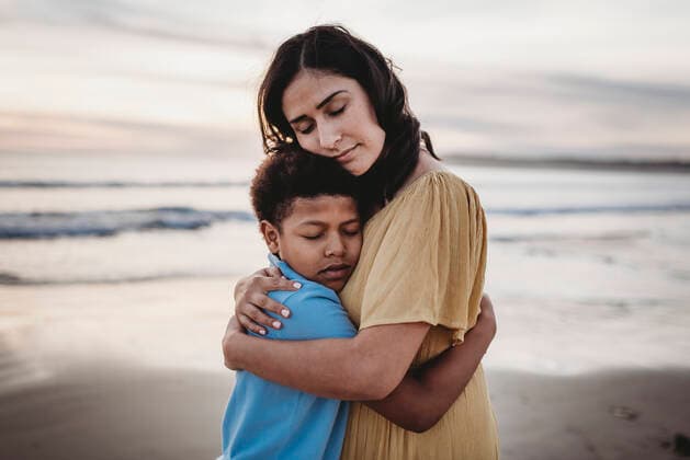IMAGO Creative: Dichotomien, Generationen Portrait of mother embracing son during sunset with eyes closed San Diego, CA, United States ,model released, Symbolfoto CR_KESM200227-264003-01