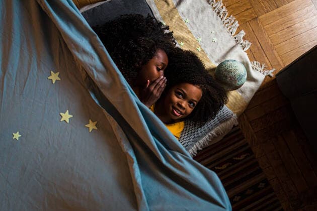 IMAGO Creative: Jahreszeit Winter, Fantasievoll drinnen spielen Overhead view of girl whispering with sister while relaxing at home New York, NY, United States ,model released, Symbolfoto ,property released CR_LIWEEE200227-318420-01