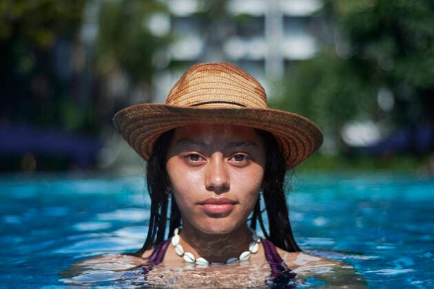 IMAGO Creative, Jahreszeit Sommer, Sonnenschutz Stylish trendy young teen visco girl in the pool wearing a straw hat Denpasar, Bali, Indonesia ,model released, Symbolfoto CR_SAAL200302A-313907-01
