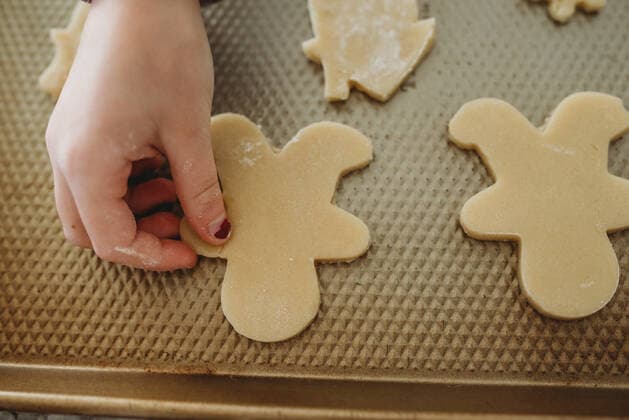 Young girl placing gingerbread on baking sheet Massapequa, NY, United States ,model released, Symbolfoto CR_ERBU200304-318445-01