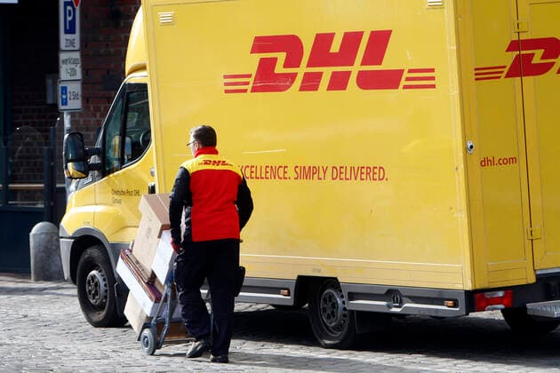 DHL Paketzusteller mit voll beladenem Karren beim Ausliefern von Paketen in der Innenstadt von Hamburg, Deutschland *** DHL parcel delivery staff with fully loaded trolley delivering parcels in the city centre of Hamburg, Germany