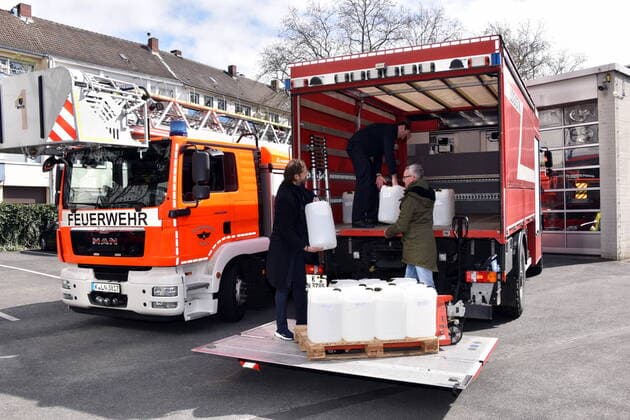 Apotheker Thomas Kelz, l-r, kölner Feuerwehrchef Dr. Christian Miller und FC Geschäftsführer Alexander Wehrle beladen LKW mit Desinfektionsmittel - Der 1 FC Köln unterstützt die Kölner Feuerwehr bei der Materialbeschaffung. In Zusammenarbeit mit dem Apotheker Thomas Kelz aus Bocholt spendet der 1. FC Köln 500 Liter Desinfektionsmittel.