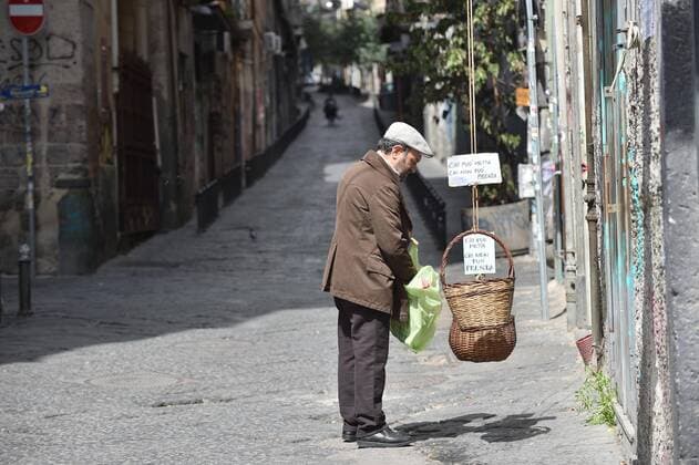 Bilder des Jahres 2020, News 03 März News Themen der Woche KW13 News Bilder des Tages Coronavirus in Italien, Der Solidaritätskorb in Neapel Foto IPP Felice De Martino Napoli 20 03 2020 Cronaca Emergenza CoronaVirus covid 19 I clochard in pellegrinaggio davanti al "panaro solidale" di Pina e Angelo di fronte al campanile di Santa Chira. Sul manico del panaro la magnifica citazione scritta a penna: "Chi puo metta, chi non puo prenda" (e la frase che Giuseppe Moscati, il medico santo, metteva all ingresso dell ambulatorio senza prendersi un soldo) Nella foto: Il panaro solidale in via Santa Chiara Italy Photo Press World Copyright  0
