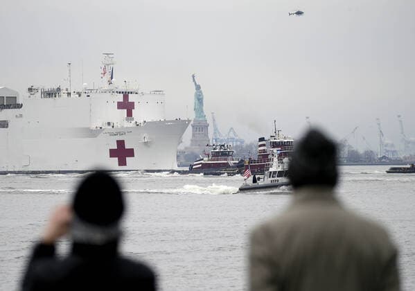 The USNS Comfort Navy ship moves past the Statue Of Liberty on route to dock at Pier 90 in the Hudson River in New York City on Monday March 30, 2020. The floating hospital in the form of a Navy ship will arrive in New York City on Monday to relieve pressure on hospitals already overwhelmed with coronavirus patients. The USNS Comfort is set to dock around 10 a.m. and it will be ready to take in patients within 24 hours.  NYP20200330109 JOHNxANGELILLO