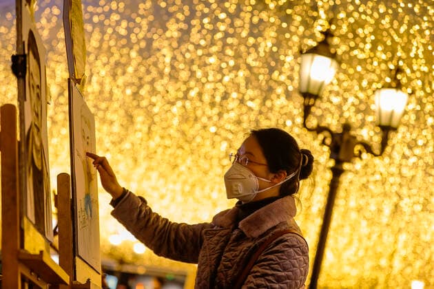 (200330) -- WUHAN, March 30, 2020 -- Zhang Jin, a street artist, draws at a commercial street in Wuhan, central China s Hubei Province, March 30, 2020. Commercial streets in Wuhan are resuming vitality as the coronavirus epidemic wanes. ) CHINA-HUBEI-WUHAN-STREET-RESUMPTION (CN) ShenxBohan 