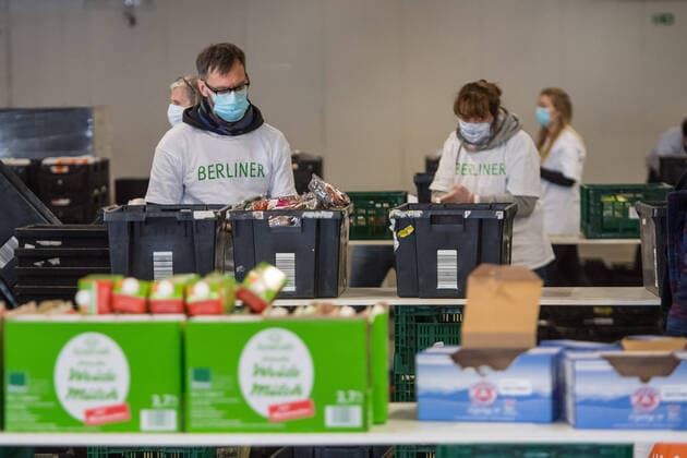 Berlin Corona-Krise Berliner Tafel Auswirkungen der Corona-Krise. Die Corona-Situation hat auch fuer die Hilfsorganisation Berliner Tafel weitreichende Konsequenzen. 42 LAIB und SEELE-Ausgabestellen mussten schliessen, nur drei der Ausgabestellen haben noch geoeffnet. Rund 50.000 beduerftige Menschen kommen ueblicherweise jeden Monat an den Ausgabestellen. Damit die Menschen weiterhin gespendete Lebensmittel erhalten koennen, beliefert die Berliner Tafel nun die Menschen zu Hause. In einer Halle auf dem Berliner Grossmarkt packen freiwillige Helferinnen und Helfer Tueten mit Lebensmitteln (im Bild), die verteilt werden. In einigen Bezirken uebernehmen Radfahrerinnen und Radfahrer der Rebel Riders mit Lastenraedern die Vor-Ort-Verteilung von Tuer zu Tuer. LAIB und SEELE ist eine Aktion der Berliner Tafel e.V., der Kirchen u