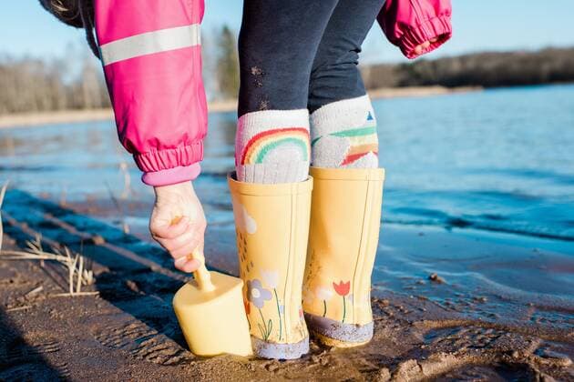 young child s rain boots and spade on a beach in the sunshine NorrtoÂ¤lje, Stockholm County, Sweden ,model released, Symbolfoto CR_RABE200320-317774-01