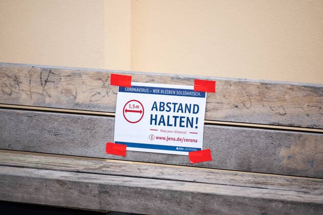 Aufkleber mit der Aufforderung des 1.5m Abstand haltens auf einer Bank im Zentrum von Jena am 30.3.2020. Innenstadt Jena