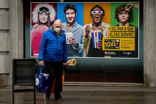 March 30, 2020, Barcelona, Catalonia, Spain: A man wearing a protective face mask passes by and ad banner in Barcelona. Daily coronavirus deaths fall slightly with 812 Covid-19 victims in the last 24 hours in Spain, Spanish government has ordered new lockdown restrictions. Barcelona Spain - ZUMAb137 20200330_zap_b137_007 Copyright: xJordixBoixareux