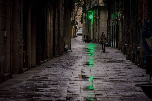 March 30, 2020, Barcelona, Catalonia, Spain: A woman wearing a protective face mask walks the empty streets of Barcelona downtown under the rain. Daily coronavirus deaths fall slightly with 812 Covid-19 victims in the last 24 hours in Spain, Spanish government has ordered new lockdown restrictions. Barcelona Spain - ZUMAb137 20200330_zap_b137_005 Copyright: xJordixBoixareux
