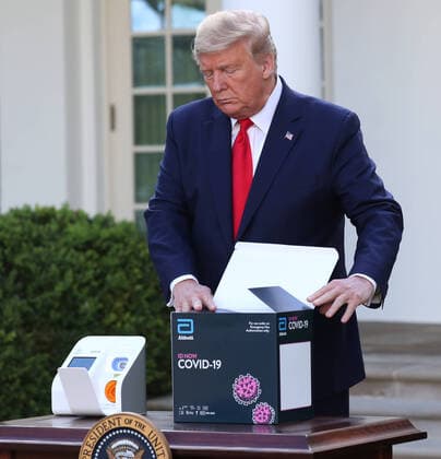March 30, 2020, Washington, District of Columbia, USA: US President Donald J. Trump opens the Abbot ID NOW COVID-19 test box during the Coronavirus Task Force press briefing on the coronavirus and COVID-19 pandemic, in the Rose Garden at the White House, in Washington, DC, USA, 30 March 2020 Washington USA - ZUMAs152 20200330_zaa_s152_014 Copyright: xMichaelxReynoldsx