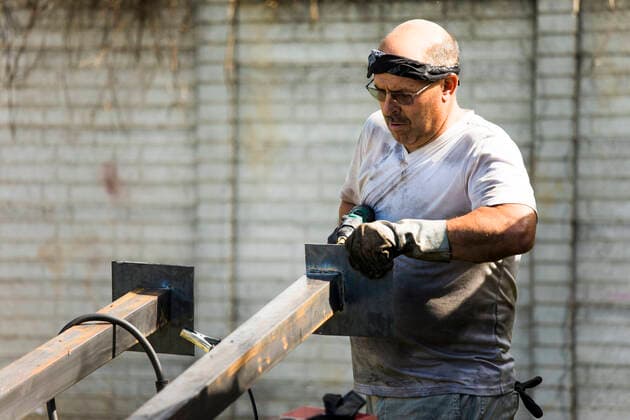 Metal worker fabricating metal posts in outdoor workshop. Monjas, Jalapa Department, Guatemala ,model released, Symbolfoto ,property released CR_JDIP200326A-316096-01