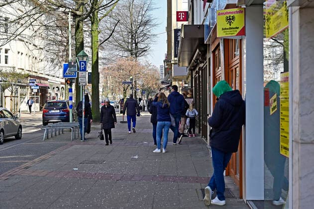 28.03.20, Essen, Nordrhein-Westfalen, Deutschland. . Zum Schutz vor Ansteckung mit dem Corona Virus hat das Land NRW verschaerfte Sicherheitsmassnahmen zur Ausbreitung des Virus verhaengt. Es gilt ein generelles Kontaktverbot. Nur noch maximal 2 Personen duerfen sich zusammen im Freien bewegen. Desweiteren gilt es einen Sicherheitsabstand von 1,5 bis 2 Metern zu anderen Menschen zu wahren. Warteschlange vor einer Baeckerei in Essen-Ruettenscheid. Alltagsleben waehrend der Corona Krise