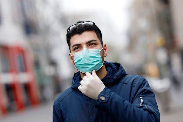 Passant mit Mundschutz in der nahezu menschenleeren Schildergasse während der Corona-Krise. Köln, 31.03.2020