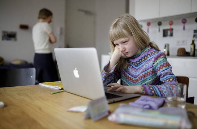 Thema: Digitaler Unterricht in Zeiten von Corona. Ein Maedchen sitzt vor einem Laptop und lernt in haeuslicher Umgebung. Berlin Deutschland
