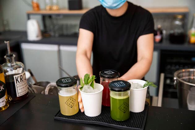 Izabela Rosiak bereitet mit Mundschutzmaske Cocktails in der Bar in der Jar in Berlin Kreuzberg am 31. Maerz 2020. Um die Verbreitung des Coronavirus (SARS-CoV-2) zu verlangsamen beschlossen Bund und Laender weitere Restriktionen. Nachdem Museen, Theatern, Sportveranstaltungen usw verboten wurden sind seit einigen Tagen weitere verschaerfte Massnahmen in Kraft getreten wie z.B. Verbot von Versammlungen in der Oeffentlichkeit mit mehr als zwei Personen, Einhaltung von Mindestabstand zwischen Personen und Schliessung von Gastronomiebetrieben mit Ausnahme von Abholung und Lieferung. Gross wird langsam die Debatte ueber die wirtschaftliche Folgen der Krise und die Laenge und Verhaeltnismaessigkeit der Restritktionen. Unternehmertum waehrend Coronavirus in Berlin
