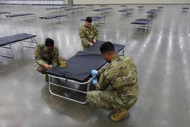 March 28, 2020, Baltimore, MD, United States of America: Maryland Army National Guard soldiers set up a cot at a Federal Medical Station to assist with COVID-19, coronavirus pandemic relief at the Baltimore Convention Center March 28, 2020 in Baltimore, Maryland. Baltimore United States of America - ZUMAp138 20200328_zaa_p138_032 Copyright: xJonxSoucy U.S.xArmyx