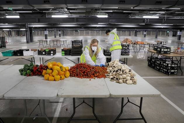 (200401) -- LONDON, April 1, 2020 (Xinhua) -- Volunteers prepare food and meals at a distribution hub in the underground car parking lot at Tottenham Hotspur Stadium in London, Britain, March 31, 2020. The distribution hub was set up by the charity Edible London, working in partnership with Haringey Council, for food distribution to vulnerable groups and workers of National Health Service (NHS). The British Government continues to try to combat the COVID-19 outbreak, while local authorities, community groups and charities are working to provide food for the most vulnerable in society. (Photo by Tim Ireland Xinhua) BRITAIN-LONDON-COVID-19-FOOD DISTRIBUTION 