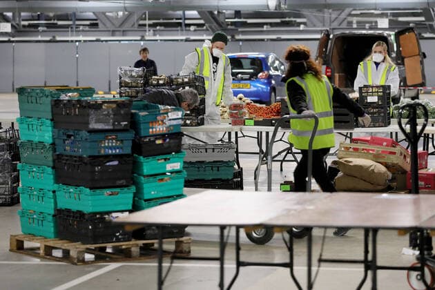 (200401) -- LONDON, April 1, 2020 (Xinhua) -- Volunteers prepare food and meals at a distribution hub in the underground car parking lot at Tottenham Hotspur Stadium in London, Britain, March 31, 2020. The distribution hub was set up by the charity Edible London, working in partnership with Haringey Council, for food distribution to vulnerable groups and workers of National Health Service (NHS). The British Government continues to try to combat the COVID-19 outbreak, while local authorities, community groups and charities are working to provide food for the most vulnerable in society. (Photo by Tim Ireland Xinhua) BRITAIN-LONDON-COVID-19-FOOD DISTRIBUTION 