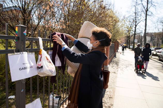 Eine Junge Frau wickelt einen Pullover auf einem Gabezaun in Berlin am 1. April 2020. Um die Verbreitung des Coronavirus (SARS-CoV-2) zu verlangsamen beschlossen Bund und Laender weitere Restriktionen. Nachdem Museen, Theatern, Sportveranstaltungen usw verboten wurden sind seit einigen Tagen weitere verschaerfte Massnahmen in Kraft getreten wie z.B. Verbot von Versammlungen in der Oeffentlichkeit mit mehr als zwei Personen, Einhaltung von Mindestabstand zwischen Personen und Schliessung von Gastronomiebetrieben mit Ausnahme von Abholung und Lieferung. Achtung: Illustrative Editorial. MR = Yes Diskussion ueber moegliche Kontrolle von Handydaten