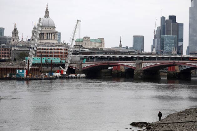 Day Nine of Lockdown in London. A person walks along the shore line on the South Bank. The country is on lockdown due to the COVID-19 Coronavirus pandemic. People are not allowed to leave home except for minimal food shopping, medical treatment, exercise - once a day, and essential work. COVID-19 Coronavirus lockdown, London, UK, on April 1, 2020 