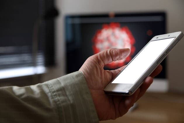 01.04.2020, Berlin - Deutschland. Verschiedene Entwickler sind dabei, eine Corona - App zu programmieren, der Blick aufs Handy zeigt den Screen.