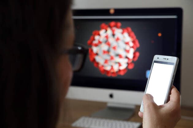 01.04.2020, Berlin - Deutschland. Verschiedene Entwickler sind dabei, eine Corona - App zu programmieren, Frau guckt auf den Screen eines Handys. Symbolfoto.
