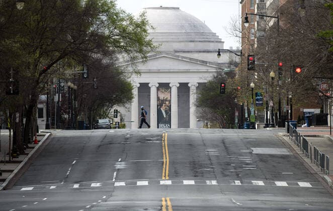 A person crosses sixth street near the National Gallery of Art after the DC Government issues a stay at home order to help combat the spread of the Coronavirus, COVID-19, pandemic, in Washington, D.C. on Wednesday, April 1, 2020.  WAP20200401310 KEVINxDIETSCH