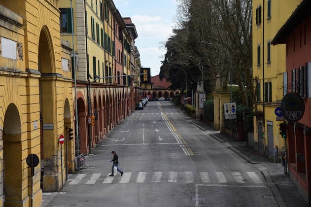 (200401) -- BOLOGNA, April 1, 2020 (Xinhua) -- A man wearing a face mask walks across a street in Bologna, Italy, on April 1, 2020. Italy registered a total of 110,574 COVID-19 cases as of Wednesday, and the death toll stood at 13,155, according to fresh figures released by the country s Civil Protection Department managing the national emergency response. (Photo by Gianni Schicchi Xinhua) ITALY-BOLOGNA-COVID-19-CASES 