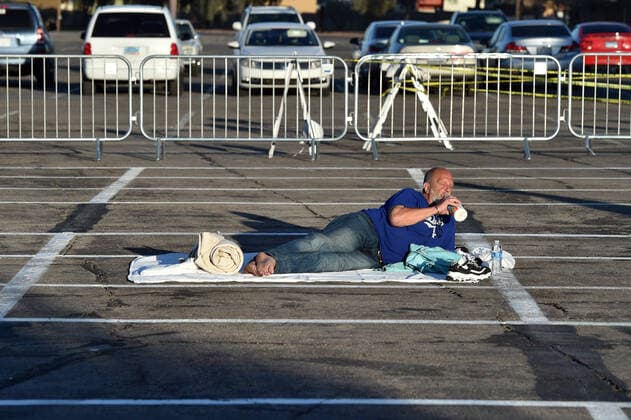 April 1, 2020 - Las Vegas, Nevada, U.S. - A man lays in an area marked by painted boxes at a temporary homeless shelter set up in a parking lot at Cashman Center amid the coronavirus pandemic on April 1, 2020, in Las Vegas, Nevada. Local officials opened the makeshift shelter after another local shelter closed when a homeless man staying there tested positive for the coronavirus. Las Vegas USA - ZUMAbk3_ 20200401_zaf_bk3_006 Copyright: xDavidxBeckerx