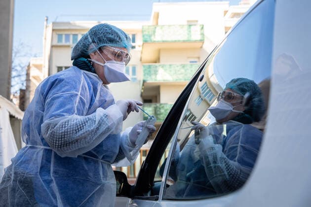 (200402) -- PARIS, April 2, 2020 (Xinhua) -- A medical biologist handles a swab to test a mediacal worker for the COVID-19 disease at a COVID-19 drive-in test center in Paris, France, April 1, 2020. A COVID-19 drive-in and screening center has opened at the City Hall of the 17th arrondissement of Paris in partnership with three laboratories in the arrondissement and is dedicated to healthcare professionals. (Photo by Aurelien Morissard Xinhua) FRANCE-PARIS-CORONAVIRUS-DRIVE IN TEST 