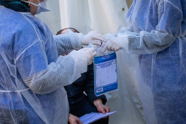 (200402) -- PARIS, April 2, 2020 (Xinhua) -- Medical biologists prepare to handle a swab to test a mediacal worker for the COVID-19 disease at a COVID-19 drive-in test center in Paris, France, April 1, 2020. A COVID-19 drive-in and screening center has opened at the City Hall of the 17th arrondissement of Paris in partnership with three laboratories in the arrondissement and is dedicated to healthcare professionals. (Photo by Aurelien Morissard Xinhua) FRANCE-PARIS-CORONAVIRUS-DRIVE IN TEST 
