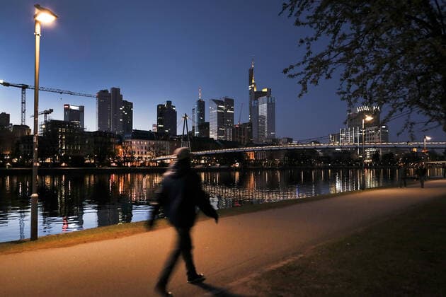 01.04.2020, Frankfurt, DEU Sonnenuntergang am Main, Buerogebaeude spiegeln sich im Main. Ein Spaziergaenger laeuft vorbei