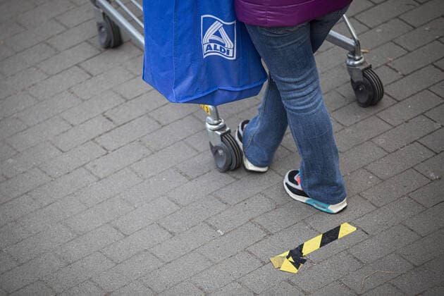 Eine Frau mit Aldi-Beutel steht mit Einkaufswagen an einer Markierung vor einem Supermarkt wartet auf den Einlass, aufgenommen in Goerlitz, 02.04.2020. Aufgrund der Verbreitung des Coronaviruses gibt es Einlassbeschraenkungen in Supermaerkten. Goerlitz Deutschland