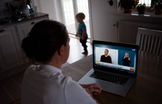 200402 En kvinna följer en tv-sändning via SVT-play där Anders Tegnell, statsepidemiolog Folkhälsomyndigheten, haller en presskonferens med anledning av Coronaviruset, Covid-19, den 2 april mars 2020 i Stockholm. Copyright: NILSxJAKOBSSON 47113310st