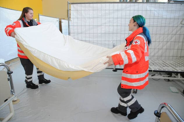 20 Helfer vom THW, DRK, DRLG und der Feuerwehr helfen am Donnerstag (02.04.2020) beim Aufbau der Betten in der Turnhalle in Marpingen. Die Sporthalle soll als Versorgungszentrum für Coronapatienten dienen. Insgesamt 42 Betten werden von den Helfern in Krankenhäusern und Pflegeheimen abgeholt und in die Turnhalle gebracht und aufgestellt.