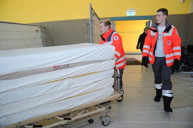 20 Helfer vom THW, DRK, DRLG und der Feuerwehr helfen am Donnerstag (02.04.2020) beim Aufbau der Betten in der Turnhalle in Marpingen. Die Sporthalle soll als Versorgungszentrum für Coronapatienten dienen. Insgesamt 42 Betten werden von den Helfern in Krankenhäusern und Pflegeheimen abgeholt und in die Turnhalle gebracht und aufgestellt.