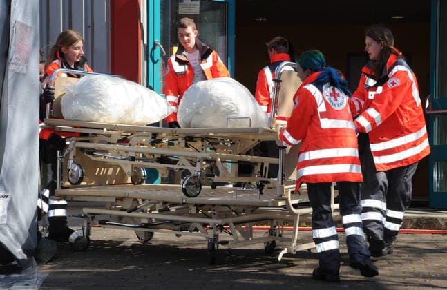 20 Helfer vom THW, DRK, DRLG und der Feuerwehr helfen am Donnerstag (02.04.2020) beim Aufbau der Betten in der Turnhalle in Marpingen. Die Sporthalle soll als Versorgungszentrum für Coronapatienten dienen. Insgesamt 42 Betten werden von den Helfern in Krankenhäusern und Pflegeheimen abgeholt und in die Turnhalle gebracht und aufgestellt.