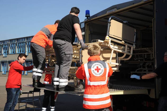 20 Helfer vom THW, DRK, DRLG und der Feuerwehr helfen am Donnerstag (02.04.2020) beim Aufbau der Betten in der Turnhalle in Marpingen. Die Sporthalle soll als Versorgungszentrum für Coronapatienten dienen. Insgesamt 42 Betten werden von den Helfern in Krankenhäusern und Pflegeheimen abgeholt und in die Turnhalle gebracht und aufgestellt.