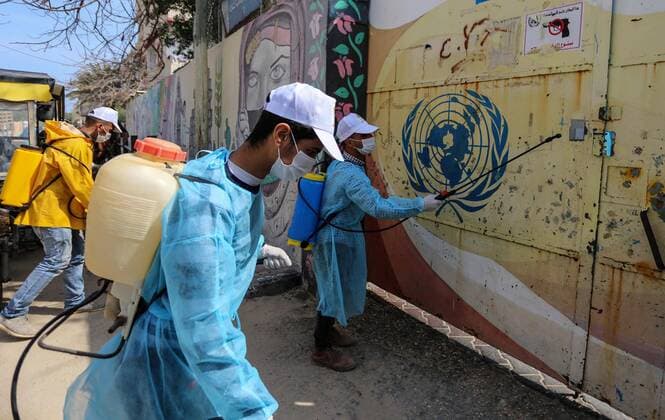 April 2, 2020, Dair Al Balah, Gaza Strip, Palestinian Territory: Palestinian workers spray disinfectant outside an UNRWA school as a preventive measure amid fears of the spread of the coronavirus disease (COVID-19), in Dair Al Balah in the center of Gaza strip, on April 2, 2020 Dair Al Balah Palestinian Territory - ZUMAap3_ 20200402_zaf_ap3_053 Copyright: xAshrafxAmrax