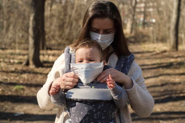 Mother protecting her baby from seasonal virus model released Symbolfoto  BZF00534